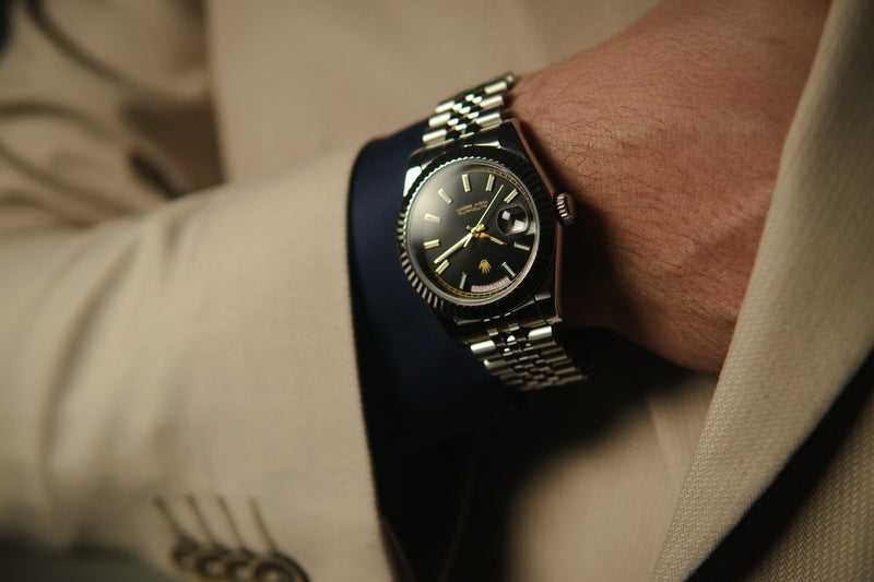 Stainless steel Valenne Destro watch on wrist with hand in pocket of the jacket, displaying the ergonomic 9 o'clock crown position.
