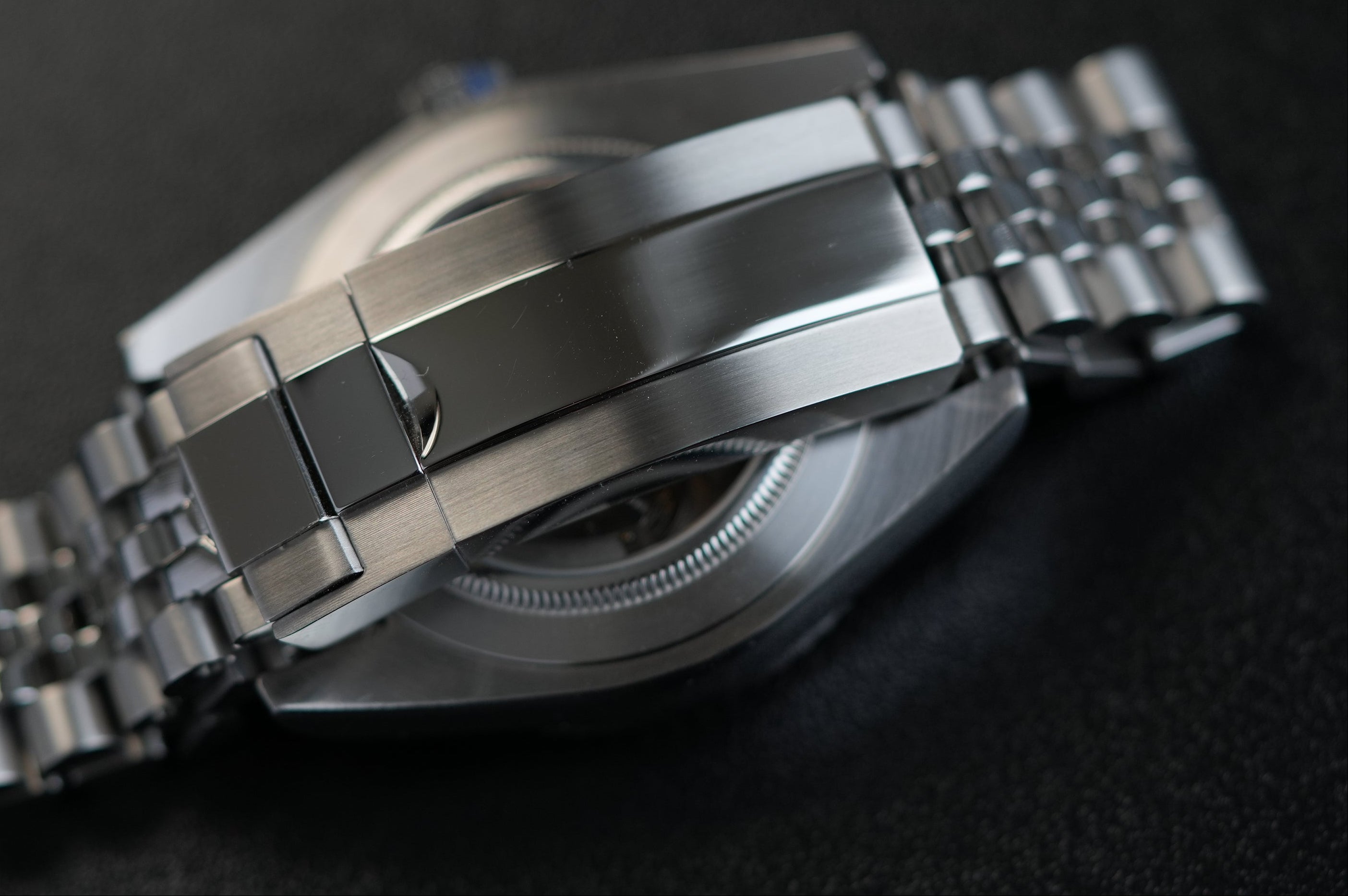 Close-up of a destro silver watch with a metallic band on a dark background