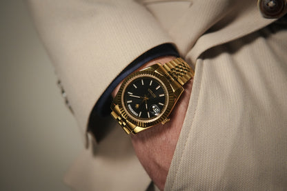 Macro lifestyle shot of the Valenne Destro watch showcasing the black sunburst dial and gold-tone hands.
